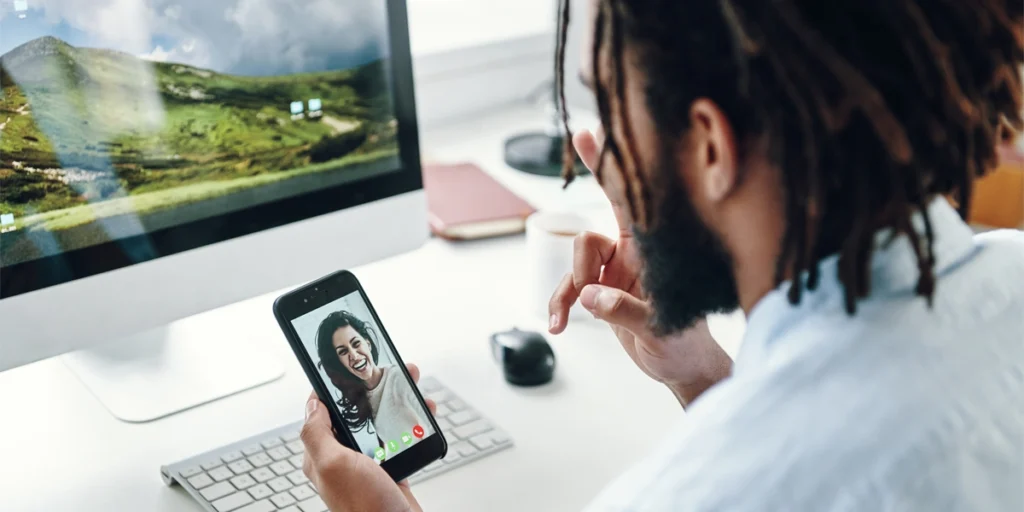 Person video chatting on a smartphone and computer.